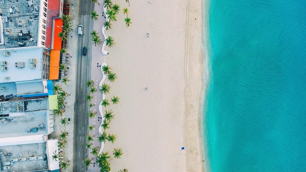 Calm turquoise sea meeting a sand shore, from above